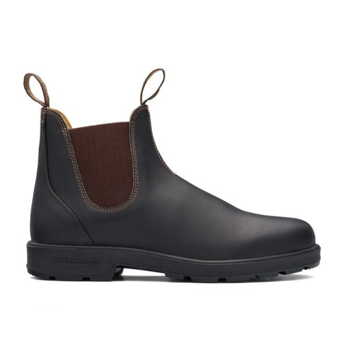 Black Chelsea boot with brown patch on a white background