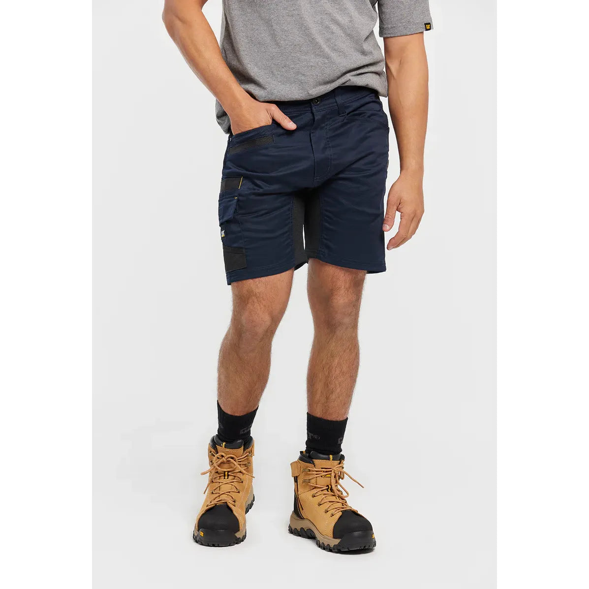 Person wearing navy cargo shorts, a gray shirt, and tan hiking boots on a white background